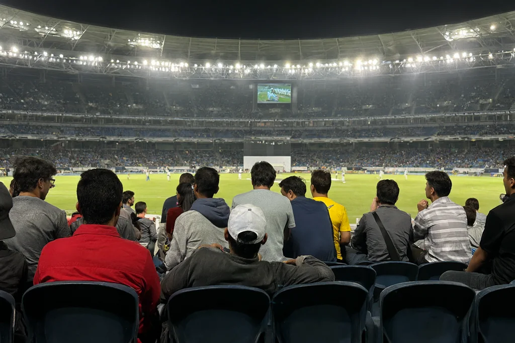 A group of cricket fans watching from the stands
